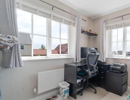 a room with a desk and a chair and windows at CrastaPrade LUXHolidayHome in Celerina
