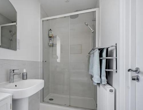 a white bathroom with a shower and a sink at CrastaPrade LUXHolidayHome in Celerina