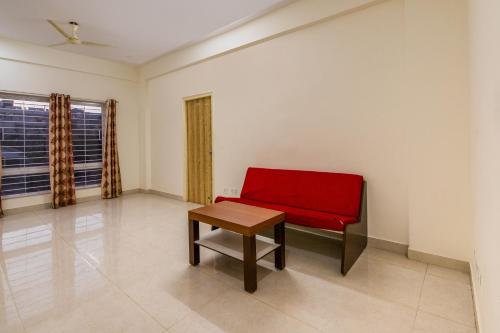 a red bench in a room with a table at Hotel O Sagar Comforts in Bengaluru
