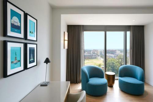 a hotel room with two blue chairs and a table at JW Marriott Reston Station in Reston