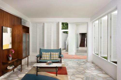 a living room with a chair and a table at Lone Pine, Penang, a Tribute Portfolio Resort in Batu Ferringhi