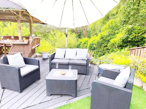 un patio con sedie, un tavolo e un ombrellone di Coulounieix Resort a Coulounieix-Chamiers
