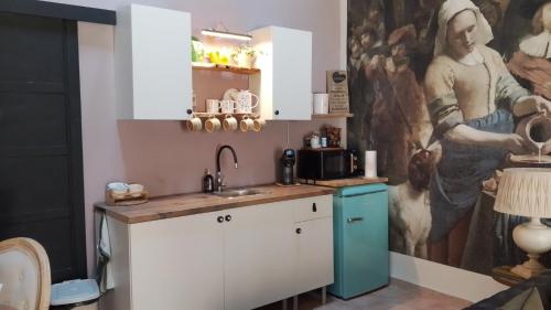 una cucina con un dipinto sul muro di Alojamiento Rural Ensueño Studio a Alcublas