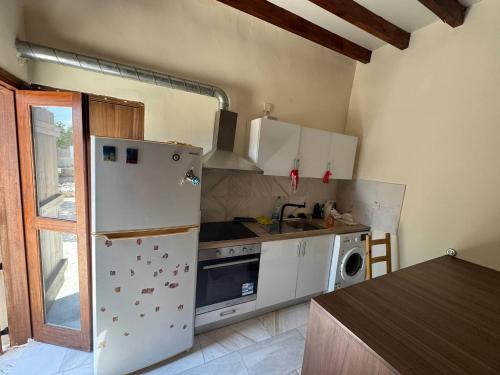 a kitchen with a refrigerator and a sink and a stove at Cozy Stone house with 1 bedroom in Marathounda