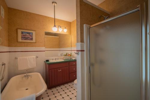 a bathroom with a tub and a sink and a shower at The Winstead Inn in Harwich