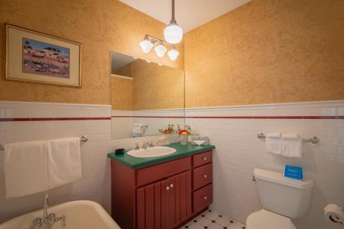 a bathroom with a sink and a toilet and a mirror at The Winstead Inn in Harwich