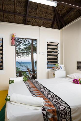 a bedroom with two beds and a view of the ocean at Funky Fish Beach & Surf Resort in Malolo