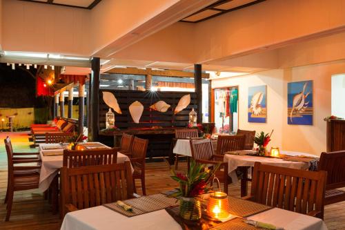 a restaurant with tables and chairs and a fireplace at Funky Fish Beach & Surf Resort in Malolo