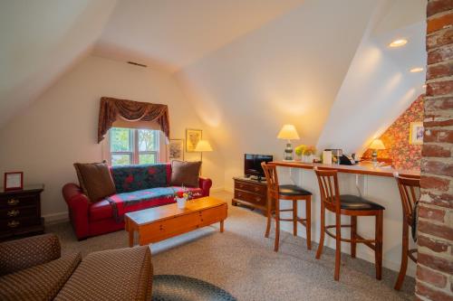 a living room with a red couch and a table at The Winstead Inn in Harwich