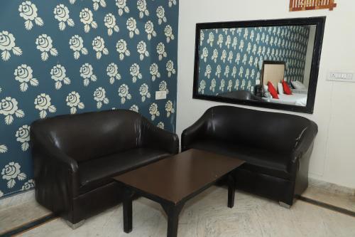 a pair of leather chairs and a table in a room at Amrit resort in Alwar