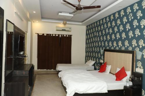 a bedroom with two beds with red pillows at Amrit resort in Alwar