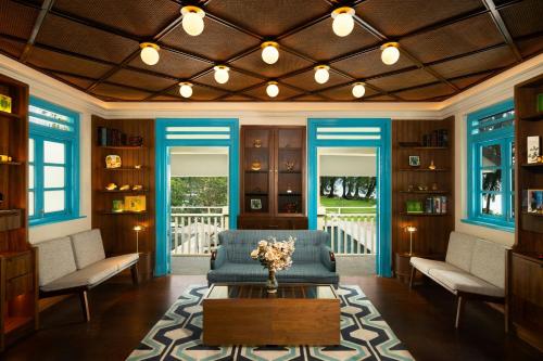 a living room with a blue couch and a table at Lone Pine, Penang, a Tribute Portfolio Resort in Batu Ferringhi