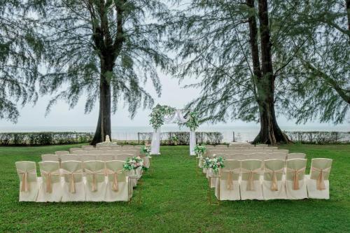 a row of white chairs with flowers on them at Lone Pine, Penang, a Tribute Portfolio Resort in Batu Ferringhi