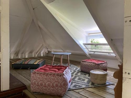 a room with two ottomans and a stool in a attic at Kafé House with breathtaking sea view in Deshaies