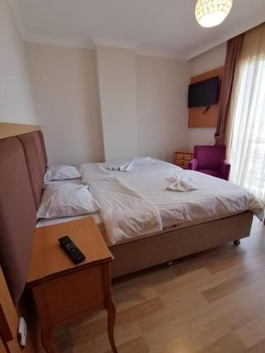a bedroom with a bed and a table with a remote control at TRABZON ınn REZİDANS in Trabzon