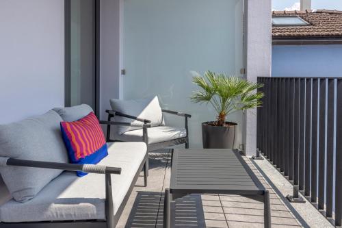a patio with a couch and a table on a balcony at Living Ascona Boutique Hotel in Ascona