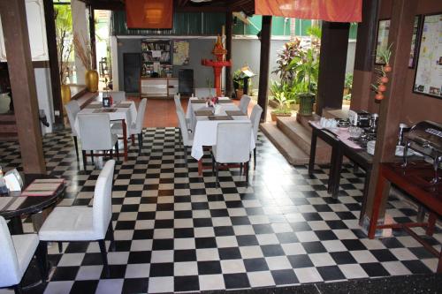 a restaurant with white tables and chairs and a checkered floor at Central Night Hotel in Siem Reap