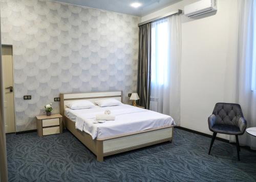 a bedroom with a large bed and a chair at A e k a hotel Y V N in Yerevan