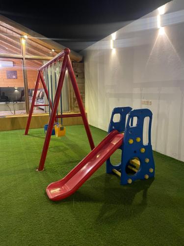a playground with two swings and a slide at اكواخ وشاليهات جولدن الفندقية in Jeddah