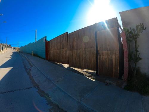 a fence on the side of a road with the sun behind it at Cabañas Coquimbo in Coquimbo
