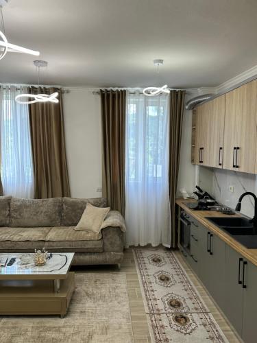 a living room with a couch and a kitchen at Puka Retreat in Pukë