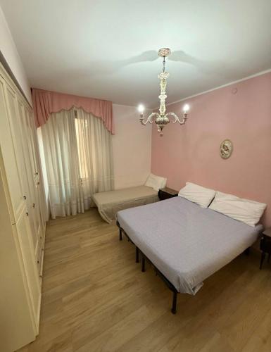 a bedroom with a bed and a chandelier at Casa GILDA in Pisogne