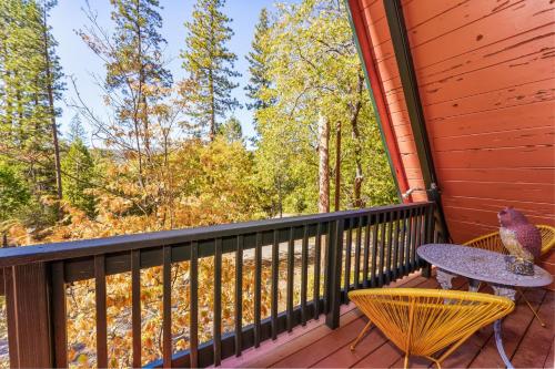 un patio avec une table et des chaises sur une terrasse dans l'établissement Sugar Pine Haus- A Frame Cabin w/ Hot Tub, à Yosemite Forks