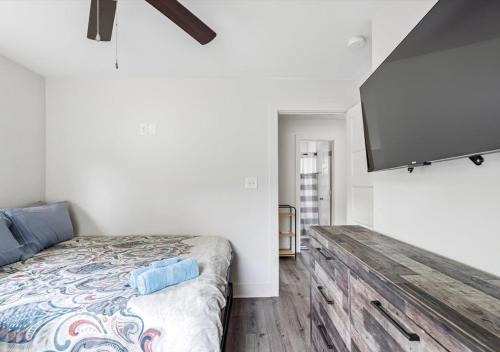 a bedroom with a bed and a flat screen tv at 2BR Haven 306C Close to Charlottes Uptown in Charlotte