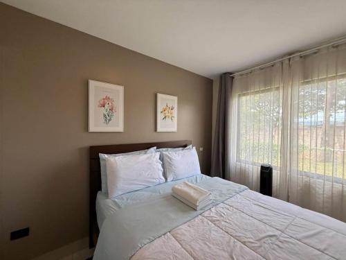 a bedroom with a large bed with a window at Tropical Sunshine in Alajuela