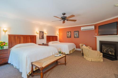 a hotel room with two beds and a fireplace at The Winstead Inn in Harwich