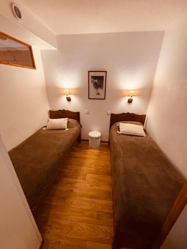 a room with two beds and a toilet in it at Appartement au pied des pistes in Les Orres