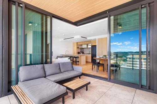 an open living room with a couch and a kitchen at Luxury Beachside Apartment - The Hemingway in Gold Coast