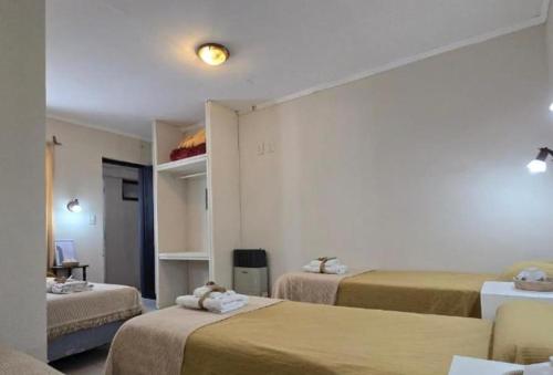una habitación con tres camas en una habitación en Praga Hotel, en Puerto San Julián