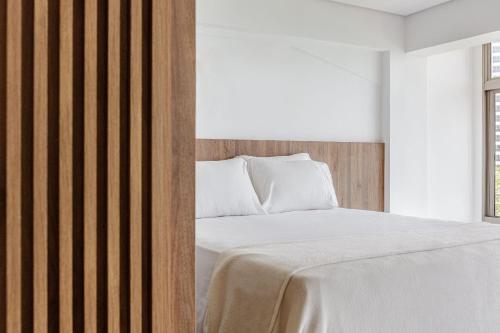 a bedroom with a bed with a wooden headboard at Beach Loft next to the Sheraton Leblon in Rio de Janeiro