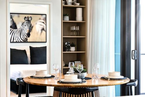 a dining room with a table and a zebra picture at Luxury Beachside Apartment - The Hemingway in Gold Coast