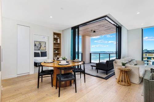 a living room with a table and a couch at Luxury Beachside Apartment - The Hemingway in Gold Coast