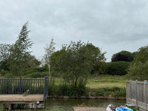 a wooden dock next to a body of water at Andreas Riverside Retreat at 7 Lakes Country Park in Crowle