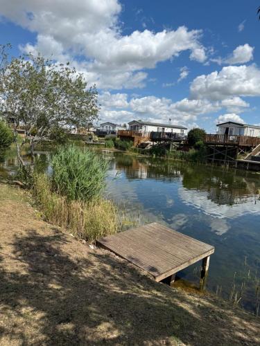 a wooden dock in the middle of a river at Andreas Riverside Retreat at 7 Lakes Country Park in Crowle
