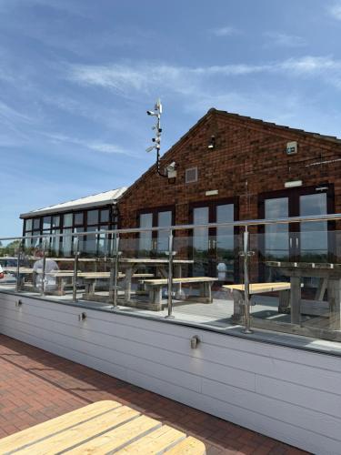 a building with benches and tables on the roof at Andreas Riverside Retreat at 7 Lakes Country Park in Crowle