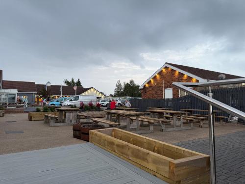 a group of picnic tables in front of a building at Andreas Riverside Retreat at 7 Lakes Country Park in Crowle