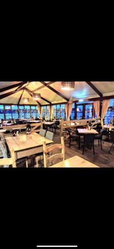a restaurant with tables and chairs in a room at Andreas Riverside Retreat at 7 Lakes Country Park in Crowle