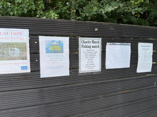 a wooden bench with signs on it at Andreas Riverside Retreat at 7 Lakes Country Park in Crowle