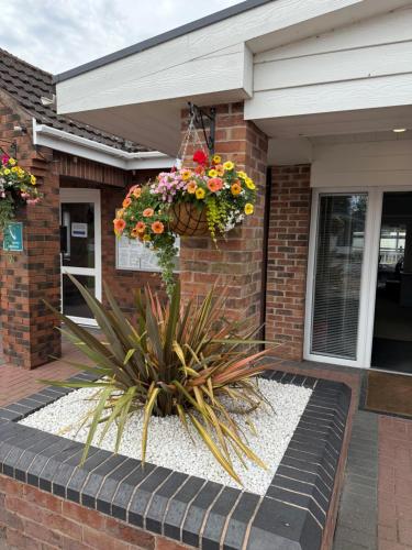 a house with a hanging basket of flowers at Andreas Riverside Retreat at 7 Lakes Country Park in Crowle