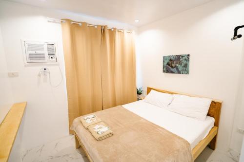 a small bedroom with a bed and a shower at MGM Tourist Inn in Tagbilaran City