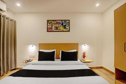 a bedroom with a large bed and a picture on the wall at Super Townhouse Swain Heritage in Bhubaneshwar