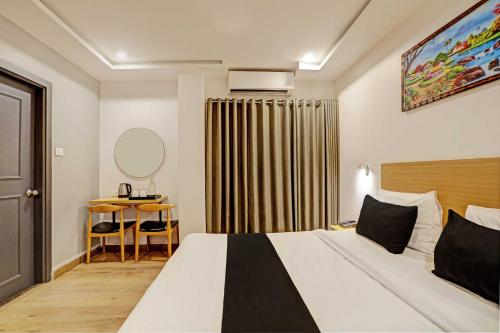 a hotel room with a bed and a table at Super Townhouse Swain Heritage in Bhubaneshwar