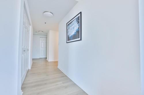 a hallway with white walls and a picture on the wall at Hudson River waterfront apt w sweeping NYC views in Hoboken