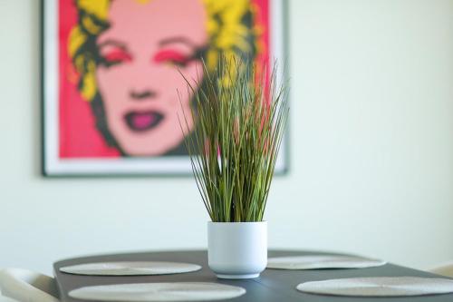 a white vase with grass in it on a table at Hudson River waterfront apt w sweeping NYC views in Hoboken
