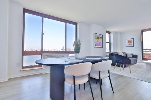 a dining room with a table and some chairs at Hudson River waterfront apt w sweeping NYC views in Hoboken