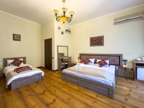 a bedroom with two beds and a chandelier at Suvenir Hotel in Baku